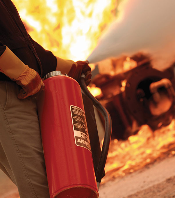 A man using RED LINE hand portable fire extinguisher