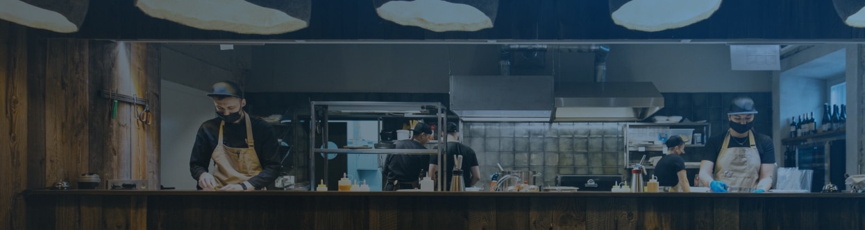 Chefs working in an open restaurant kitchen, overlaid with a blue gradient